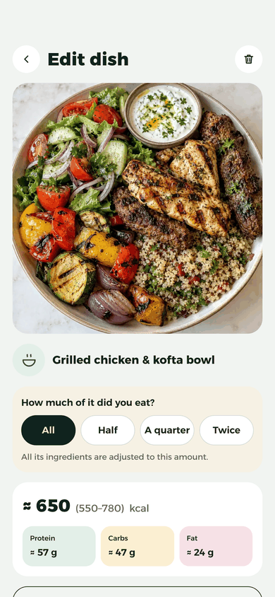 La schermata “Modifica piatto”: la foto di una ciotola di pollo alla griglia e kofta con quinoa e insalata, le scelte di “Quanto ne hai mangiato?” e ≈ 650 kcal in tutto, con proteine ≈ 57 g, carboidrati ≈ 47 g e grassi ≈ 24 g.
